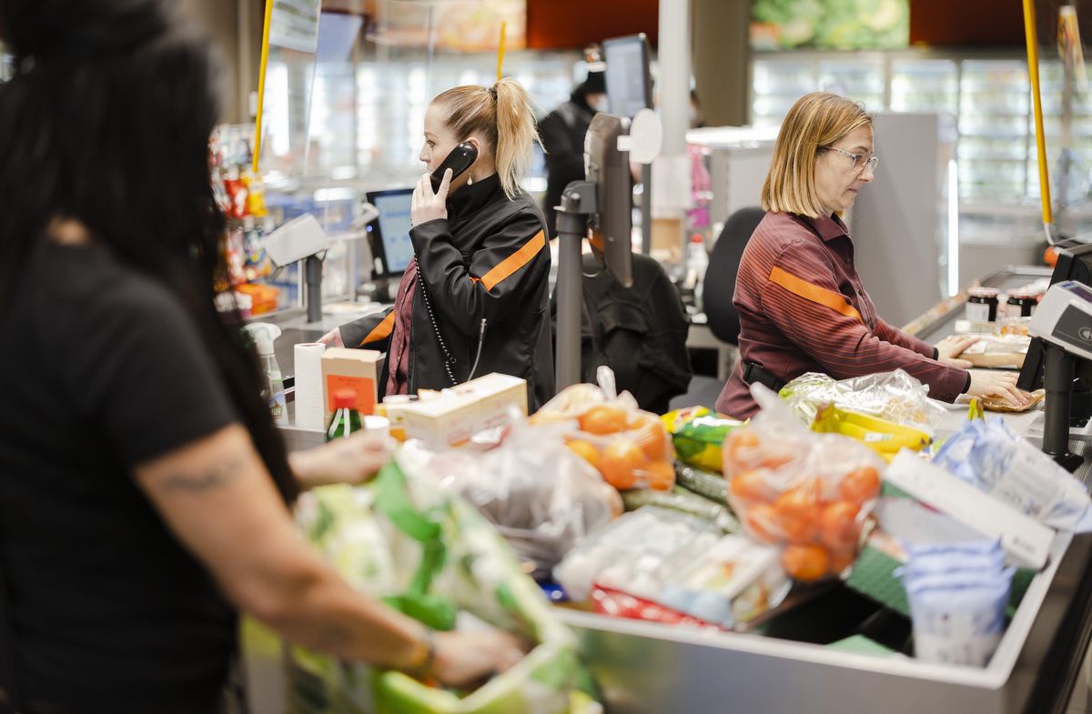 Les vendeuses Stefania Kaufmann et Arbenita Dalipi servent des clients dans un supermarché Migros à Limmatplatz, Zurich, après la levée des mesures sanitaires, le 17 février 2022.