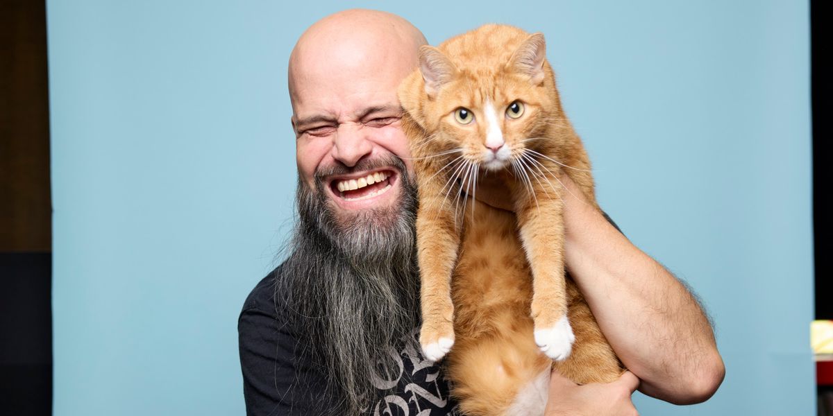 Oliver Muff, patron du Sunset Bar, souriant et tenant son chat orange à Martigny le 25 septembre 2024.