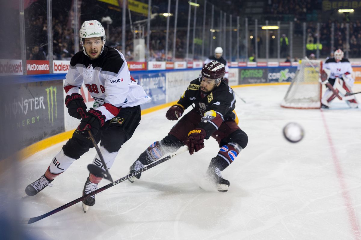 Lukas Frick (LHC) et Josh Jooris (GSHC) en action lors du match de National League entre le Geneve-Servette Hockey Club et le Lausanne Hockey Club à la Patinoire des Vernets, le 23 décembre 2023.