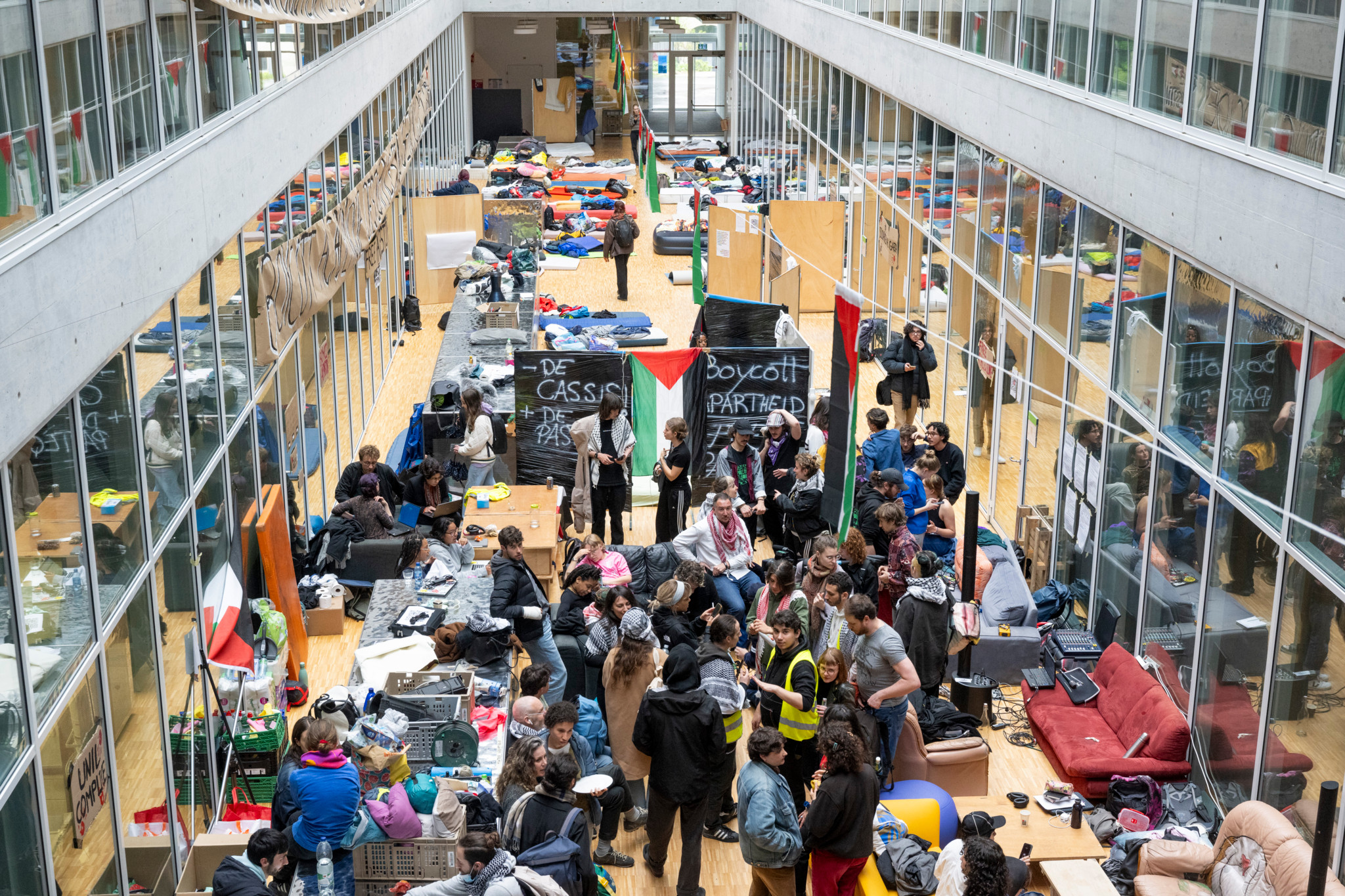 Pro-palästinensische Demonstranten besetzen die Halle des Géopolis-Gebäudes der Universität Lausanne mit Transparenten und Schlaflagern.