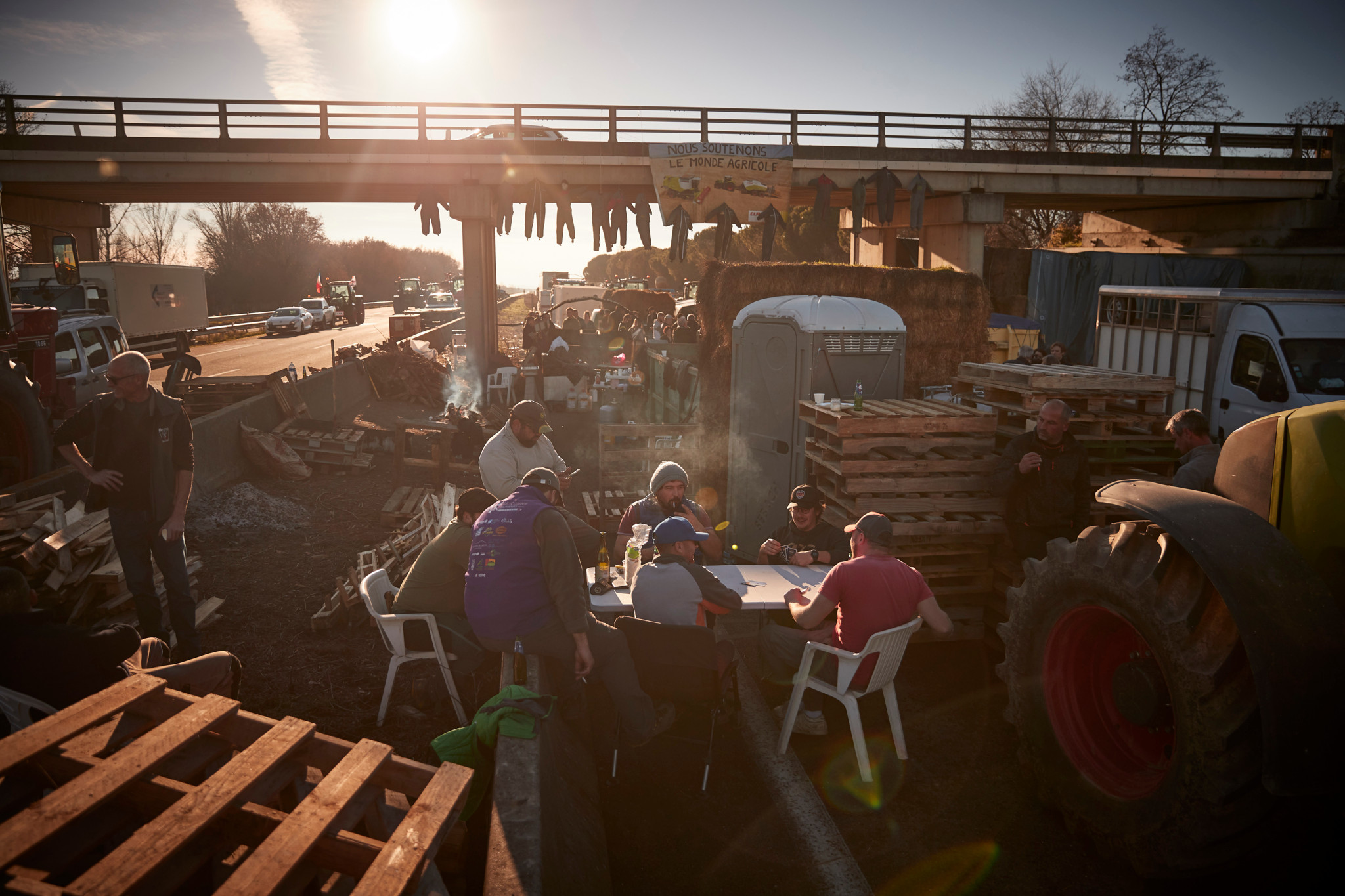 CARBONNE FRANCE - JANUARY 25: Farmers play cards at a farmer's blockade of the A64 highway, south of Toulouse, as farmers continue their demand for government action for their industry on January 25, 2024 in Carbonne, France. French Farmers, the EU's biggest agricultural producer, are blocking roads across France in protest against declining income and over regulation as protests in the European Union's agricultural sector spread. (Photo by Kiran Ridley/Getty Images)