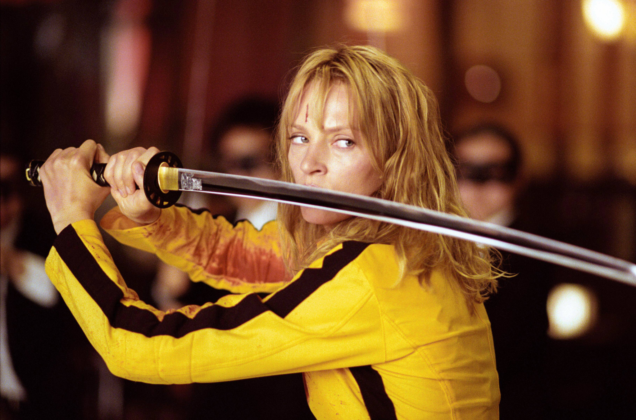 Uma Thurman als The Bride in gelbem Kampfanzug mit Katana-Schwert in Quentin Tarantinos Kill Bill Volume 1 (2003).