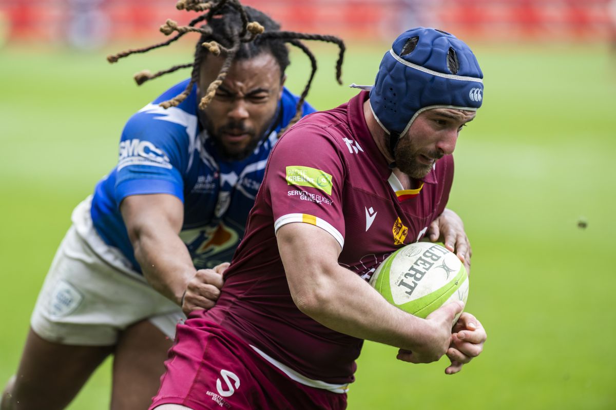 Jeremy Scalese du Servette Rugby Club de Geneve, droite, lutte pour le ballon avec Nicolas Pelsy, gauche, d'Union sportive Annecy rugby, lors de la rencontre du championnat de France de 1ere division federale, (Federale 1), entre le Servette Rugby Club de Geneve et le l'Union sportive Annecy rugby, ce dimanche 16 avril 2023 au stade de Geneve. (KEYSTONE/Martial Trezzini)