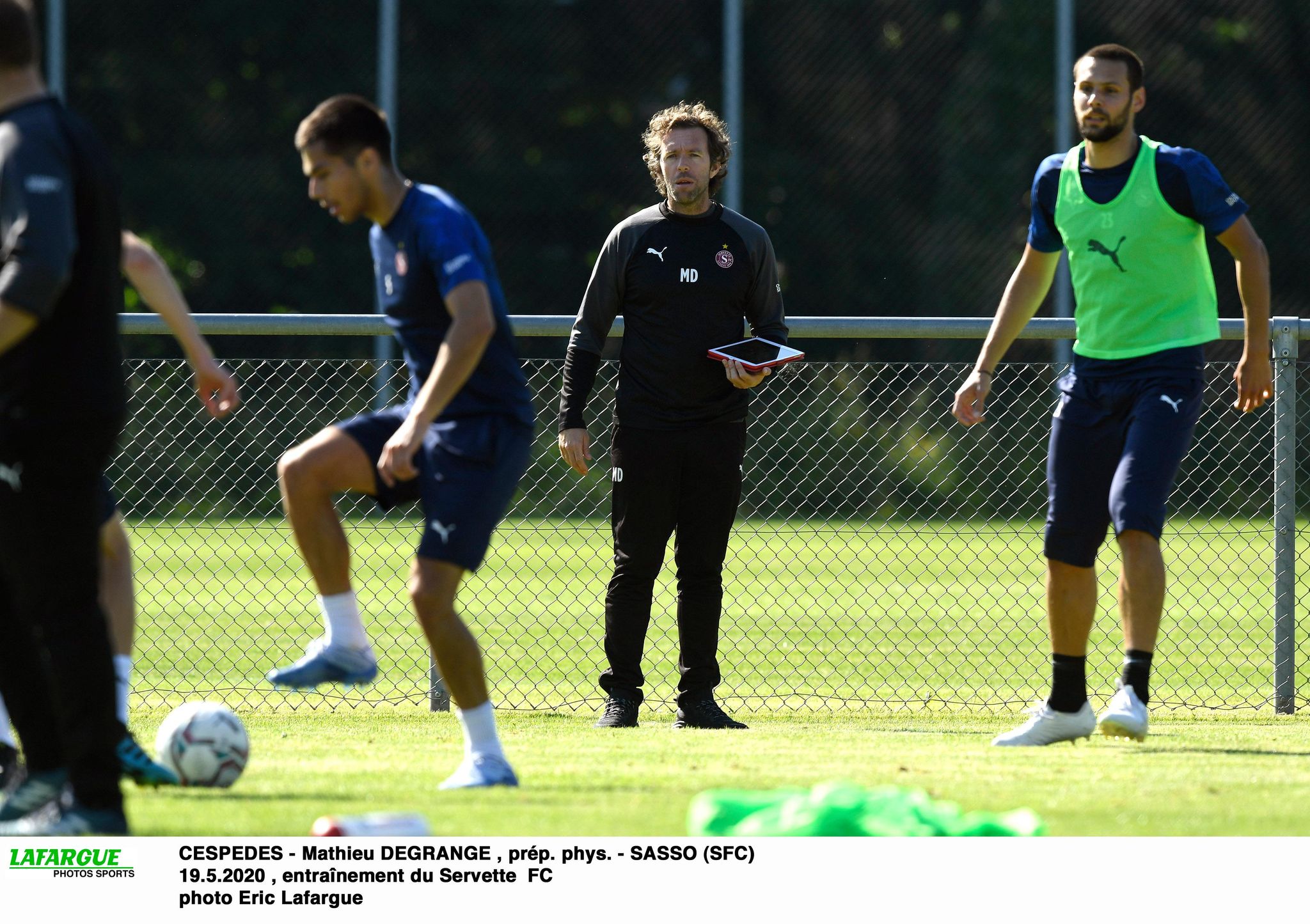 Mathieu Degrange observe avec attention Boris Cespedes effectuer un exercice avec le ballon.
