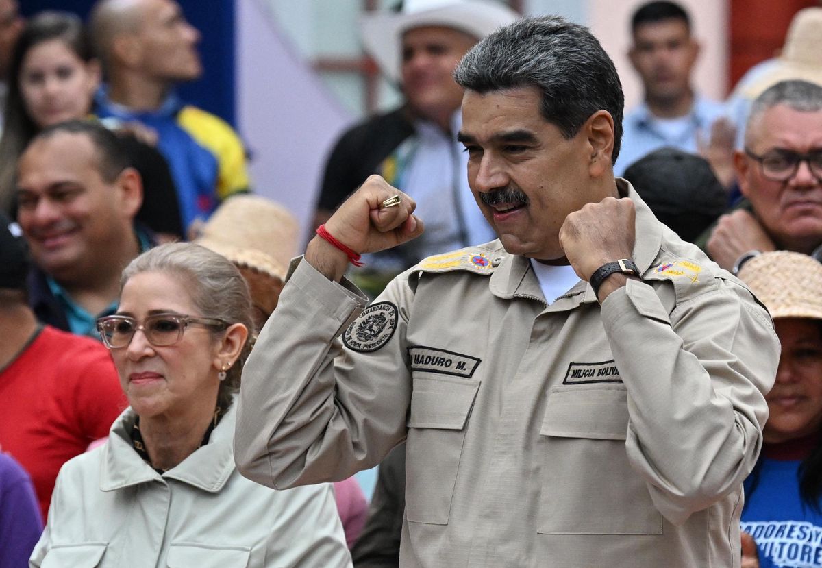 Le président vénézuélien Nicolas Maduro, levant les poings, aux côtés de la première dame Cilia Flores lors de l’événement du 165e anniversaire de la bataille de Santa Inés à Caracas.