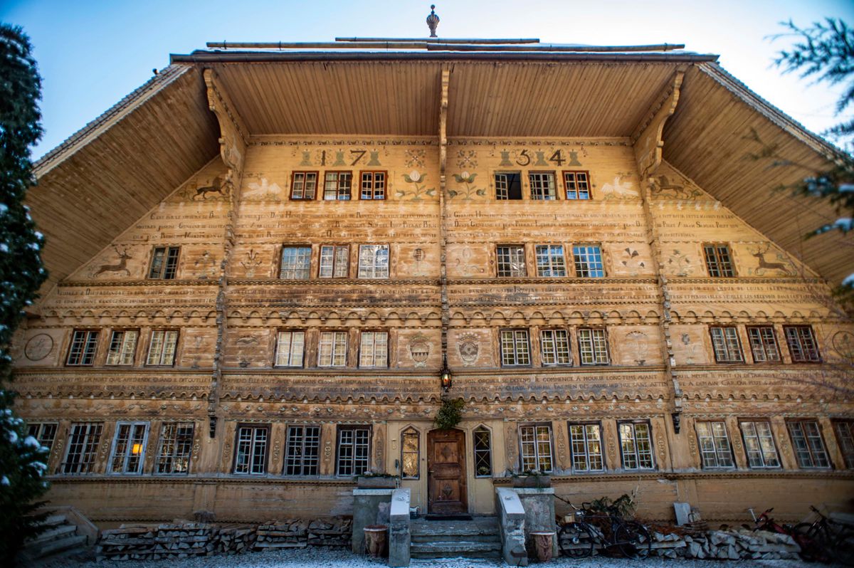 Façade du Grand Chalet de Rossinière, une imposante maison en bois avec 113 fenêtres et des dédicaces peintes. Construit entre 1752 et 1756, ce chalet était autrefois la résidence du peintre Balthus.