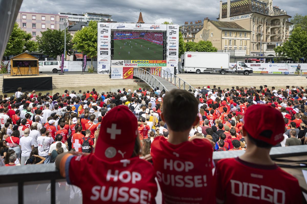 Swiss soccer fans react during the live broadcast of the UEFA EURO 2024 soccer match between Hungary and Switzerland in a fan zone in Lausanne, Switzerland, Saturday, 15. June 2024.(KEYSTONE/Cyril Zingaro)