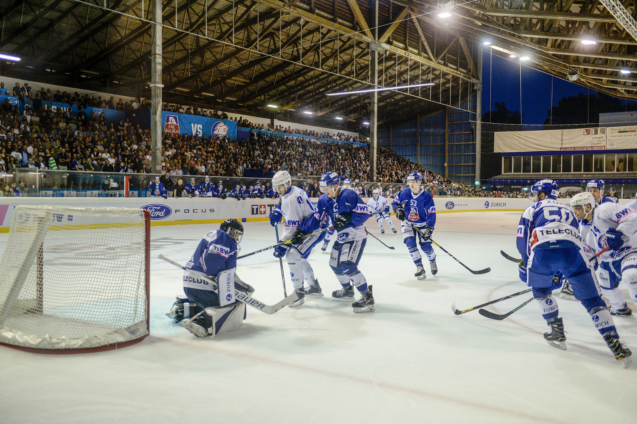 Schweizer Cup Eishockey: EHC Bülach gegen ZSC Lions in der vollbesetzten Hirslen Halle, Spieler kämpfen vor dem Tor.