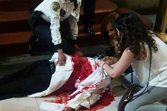 Des images diffusées sur les réseaux sociaux montrent des personnes portant secours à un prêtre en robe blanche.