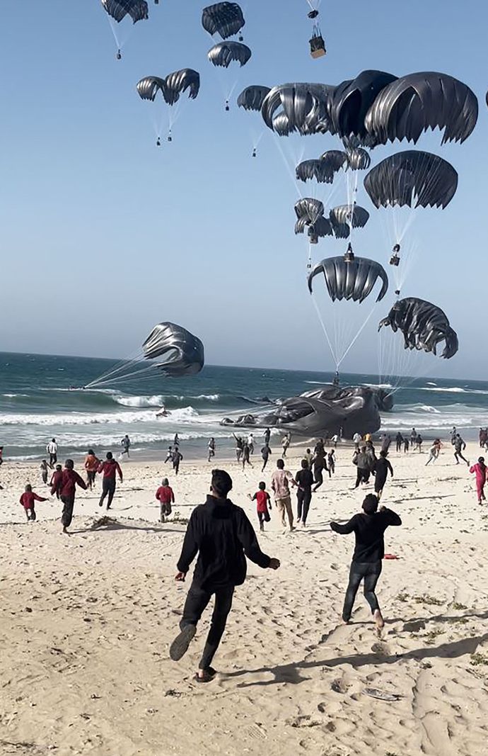 Capture d’écran d’une vidéo montrant des Palestiniens courant vers des parachutes attachés à des colis alimentaires, largués par des avions américains sur une plage de la bande de Gaza, le 2 mars 2024. Les États-Unis, principal allié d’Israël, ont déclaré avoir commencé à larguer de l’aide dans la bande de Gaza ravagée par la guerre.