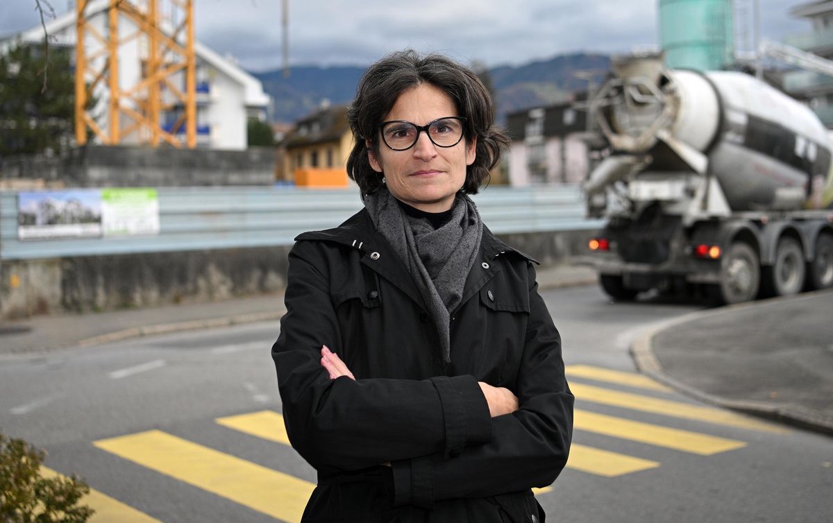 Sandra Pasquier, syndique de la Tour-de-Peilz, pose devant le chantier PPE Traménaz avec un camion de ciment en arrière-plan.