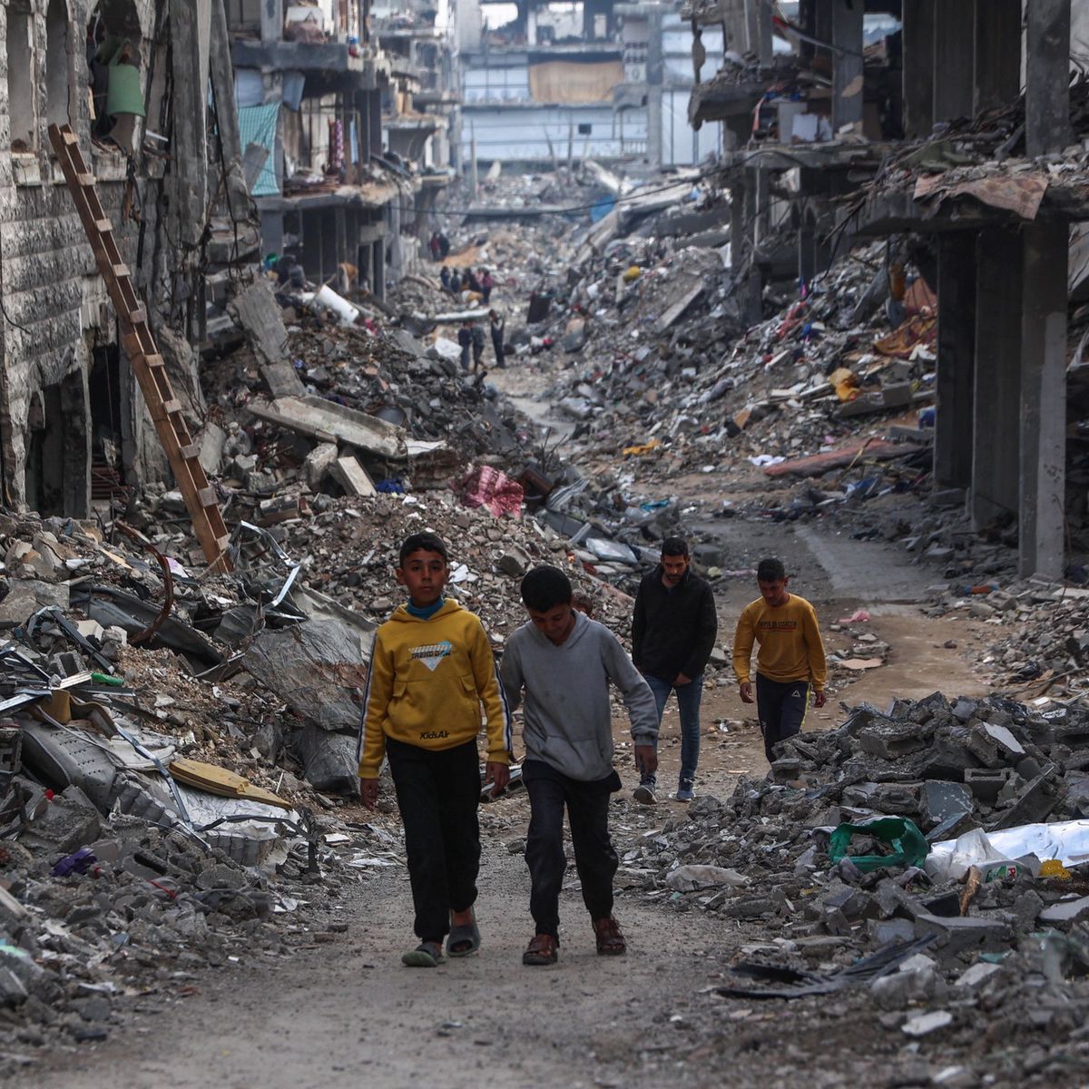 Des Palestiniens marchent dans un quartier dévasté de Beit Lahia, Gaza, avant l’iftar durant le Ramadan, le 9 mars 2025. Les débris et les bâtiments endommagés témoignent du conflit.