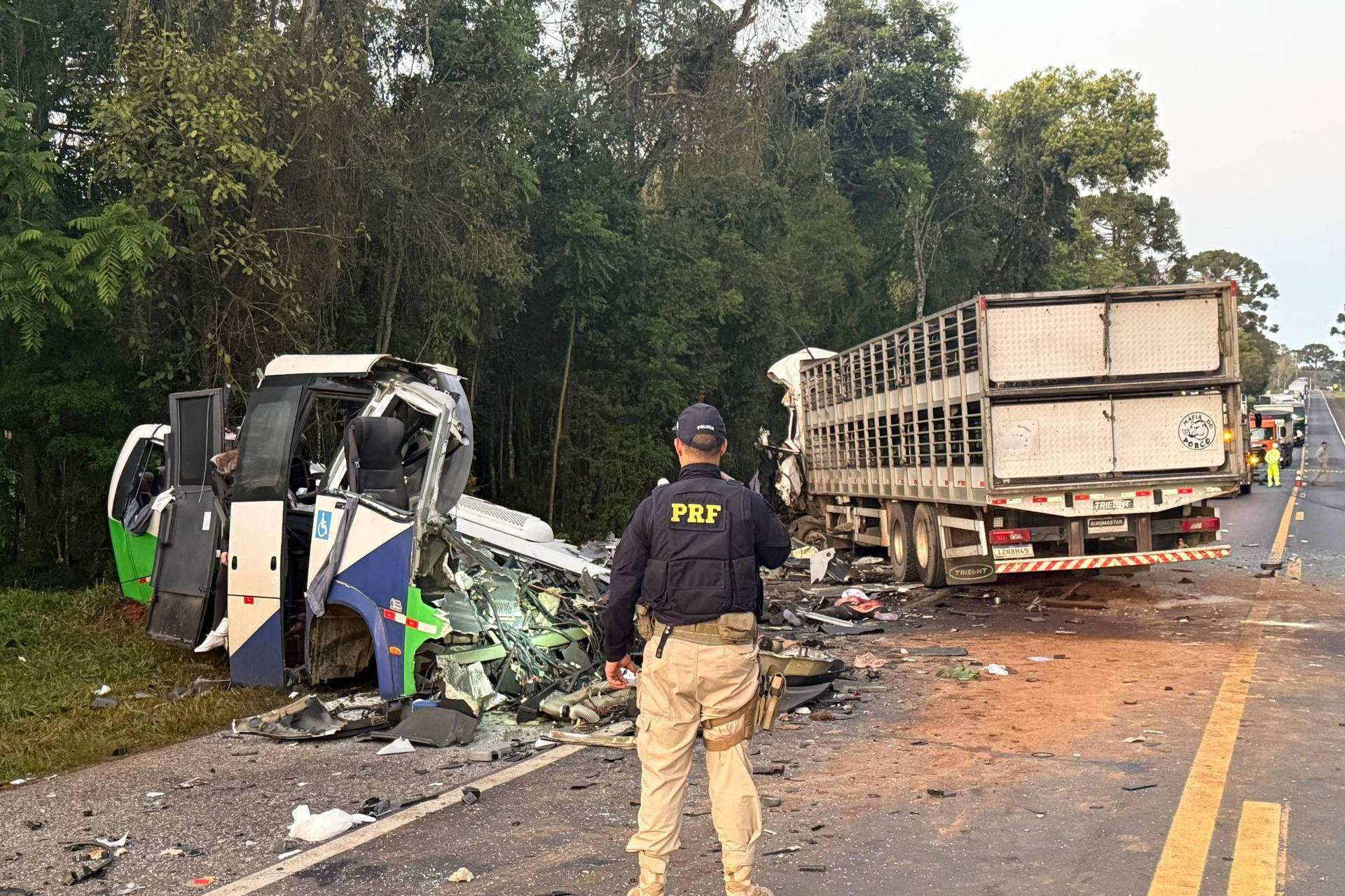 PRF-Beamter steht vor schwerem Busunfall auf brasilianischer Strasse, zerstörter Reisebus und Lastwagen nach Kollision