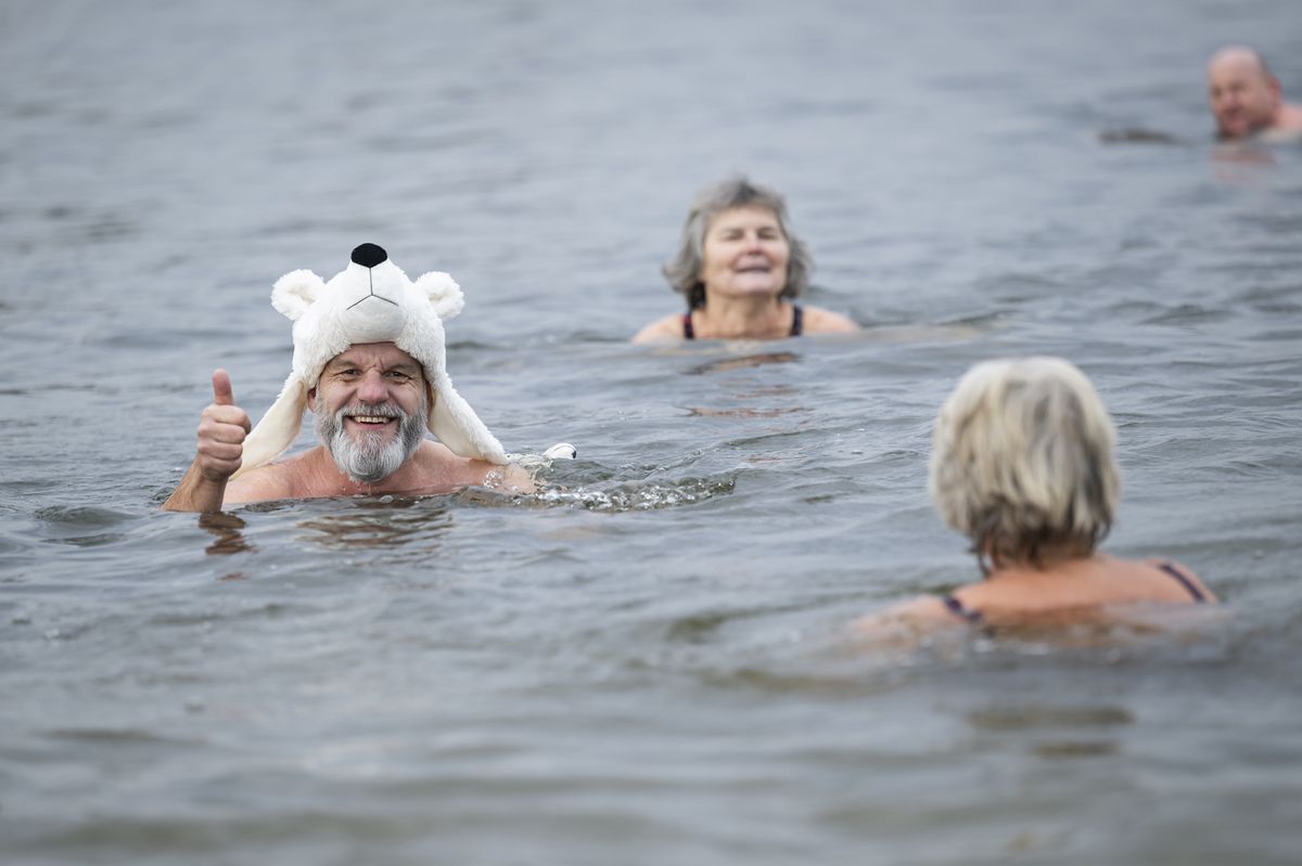 Swimmers swimm during the traditional Sylvester swim at lake Moossee in Moosseedorf, Switzerland, Sunday, December 31, 2023. The tradition has existed since 1999. On December 31, around fifty bathers gathered at the "Moossee" lake in Moosseedorf (BE) to take a dip in water measured at between 5 and 6 degrees Celsius. The story goes that the end-of-year bath washes away old sins, allowing the New Year to pass with a purified body and mind. The New Year's Eve swim is organized by the "Ysheilige Moossse" winter swimming club. Members train from the end of September to the end of April. (KEYSTONE/Anthony Anex)