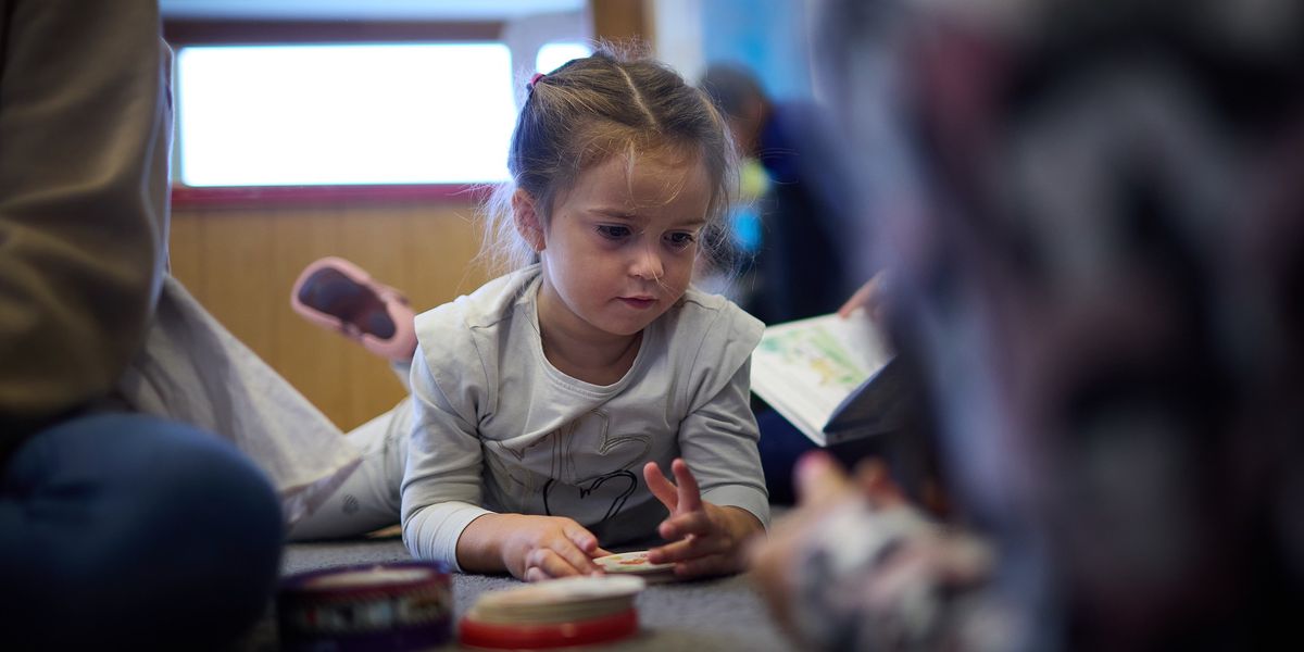 Romy joue par terre au collège du Crêt-du-Chêne à Neuchâtel avant le repas de midi, dans le cadre de l’horaire continu expérimental.
