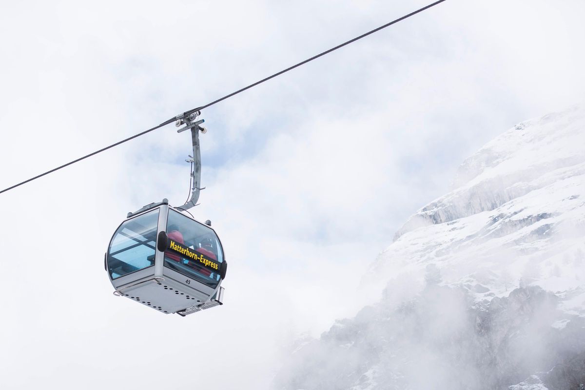 Gondole du Matterhorn-Express à Zermatt, dans le Valais, devant un fond nuageux et montagneux.