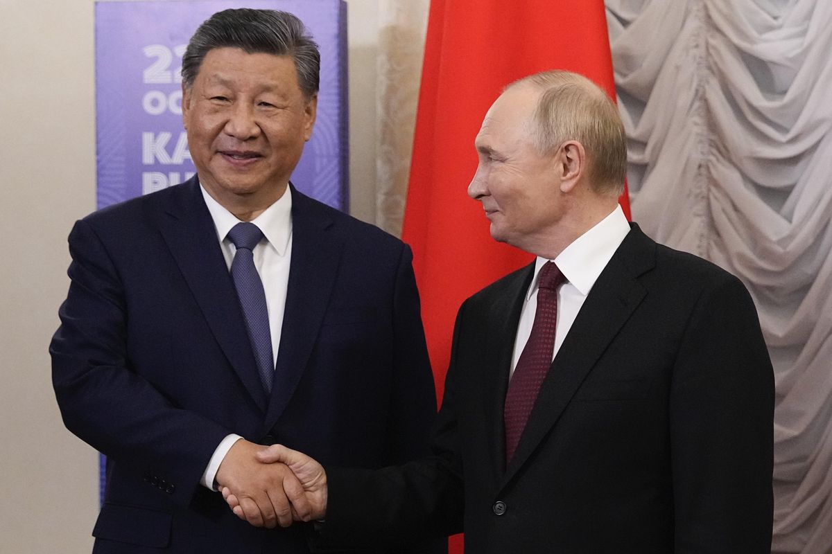 Le président russe Vladimir Poutine et le président chinois Xi Jinping se serrent la main lors du sommet des BRICS à Kazan, Russie.