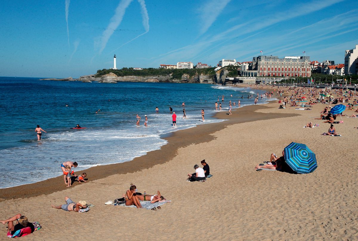 People sunbathe at Biarritz beach, southwestern France, Tuesday, Oct. 19, 2021 where the temperature rose to 29 degrees Celsius (84.2 degrees Fahrenheit). Weeks before leaders gather for a U.N. summit in Glasgow, recent scientific reports paint a dire picture of the international effort to curb greenhouse gas emissions, and the U.N. warned that more needs to be done if the goals of the 2015 Paris climate accord are to remain within reach. (AP Photo/Bob Edme)