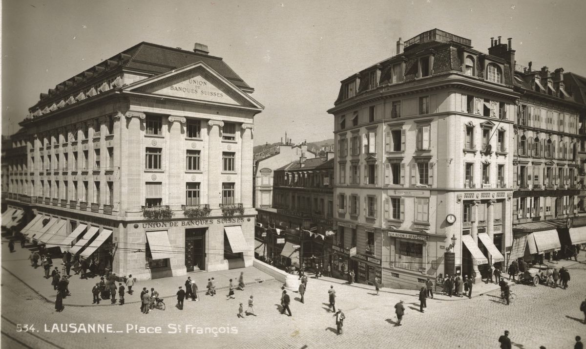Une carte postale de 1935 figurant, à gauche, l’édifice de l’Union de banques suisses. À droite, le Tea-room Saint-François. Le Café romand n’apparaîtra qu’en 1951, dans un nouvel immeuble.