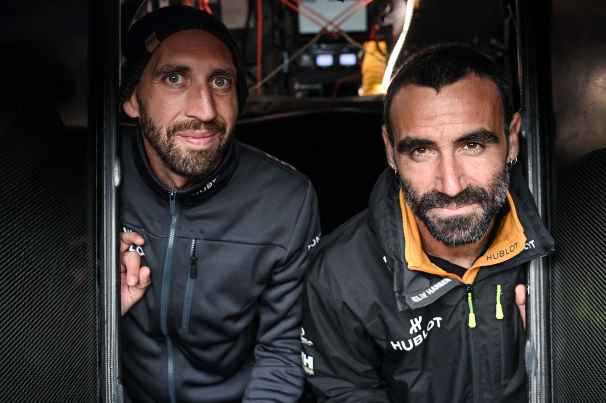 Les skippers suisses Simon Koster (à gauche) et français Alan Roura (à droite) posent à bord de leur monocoque Imoca 60 Hublot, deux jours avant le départ de la course Jacques Vabre, au Havre, dans le nord de la France, le 27 octobre 2023.