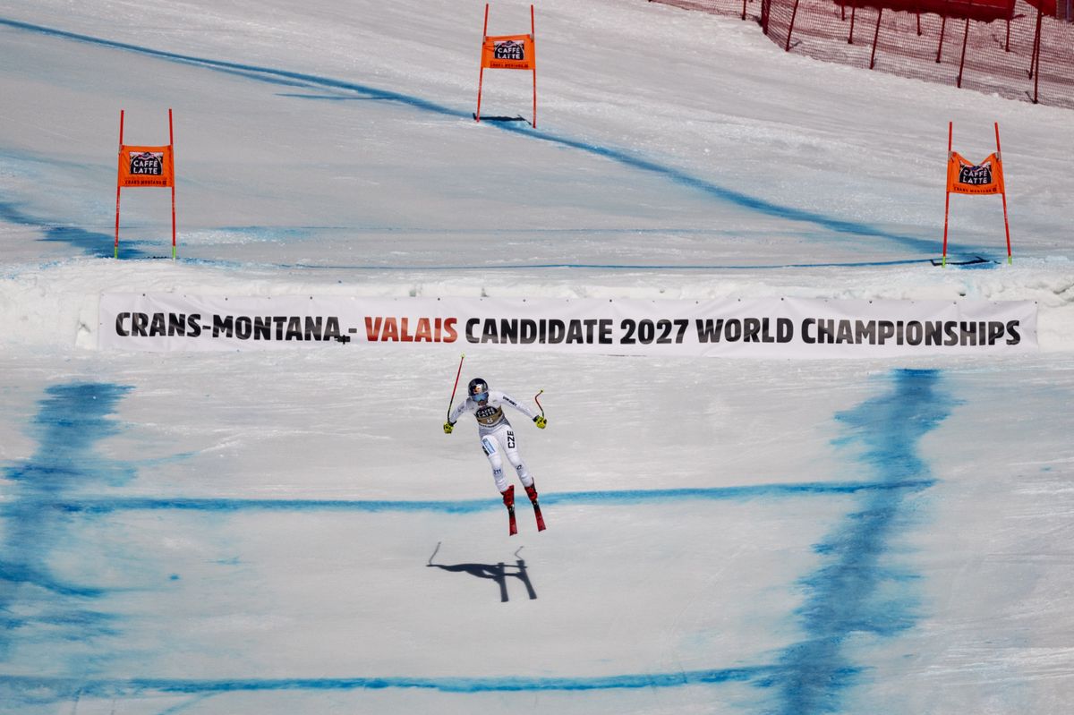 Ester Ledecka of Czech Republic is airborne on the final jump during the women's Downhill race at the FIS Alpine Ski World Cup in Crans-Montana, Switzerland, Saturday, February 26, 2022. The banner mentions the candidature of the Valais for the 2027 FIS Ski Alpine World Championsships. (KEYSTONE/Alessandro della Valle)