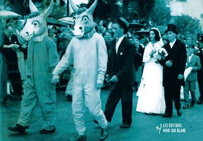 Couverture du livre 'Les enfants de Sainte Marguerite' d'Ante Tomić, montrant des personnes déguisées en têtes d'âne dans une procession, avec un couple de mariés en arrière-plan.