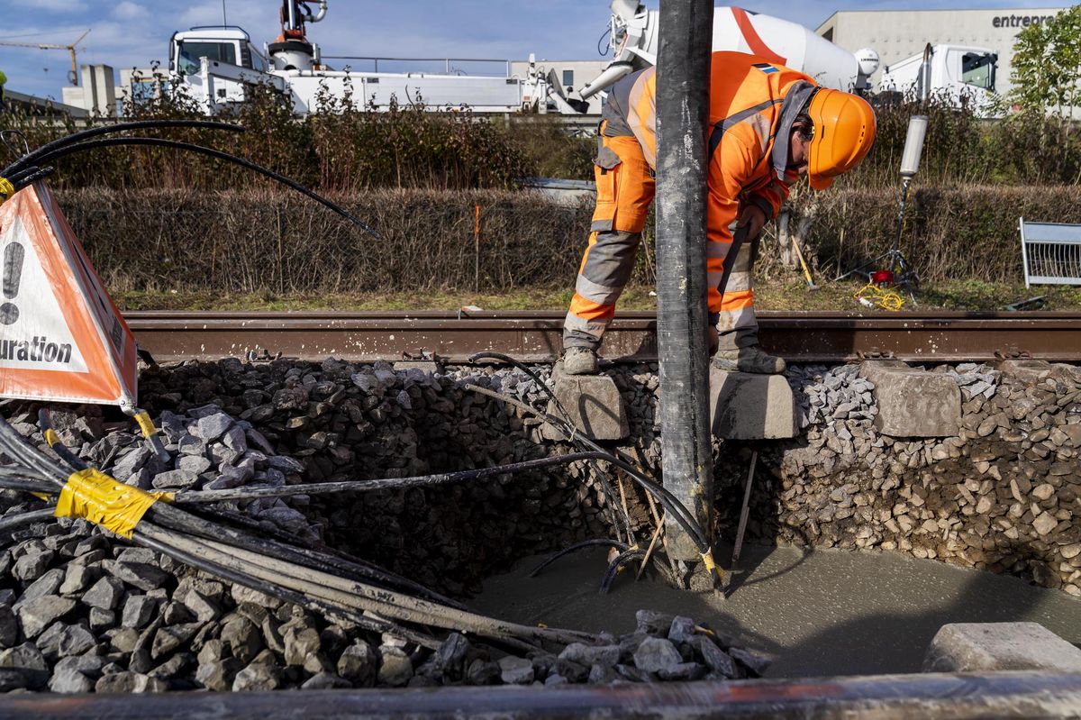 Des ouvriers bouchent le trou avec du béton sur la ligne CFF/SBB entre Lausanne et Genève à la suite d’un affaissement survenu en bordure de voie le mercredi 10 novembre 2021 à Tolochenaz.