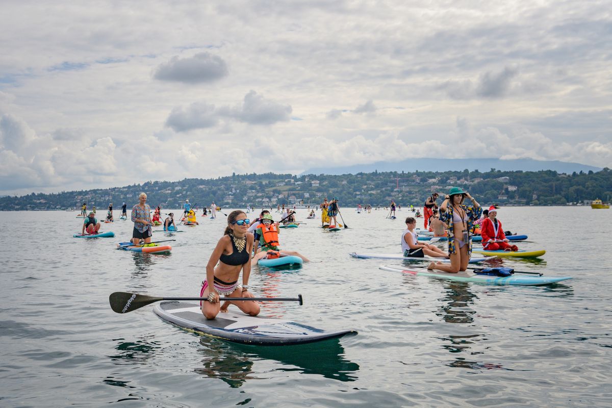 Participants déguisés font du stand up paddle sur le lac de Genève lors d'un événement gratuit organisé par la ville.