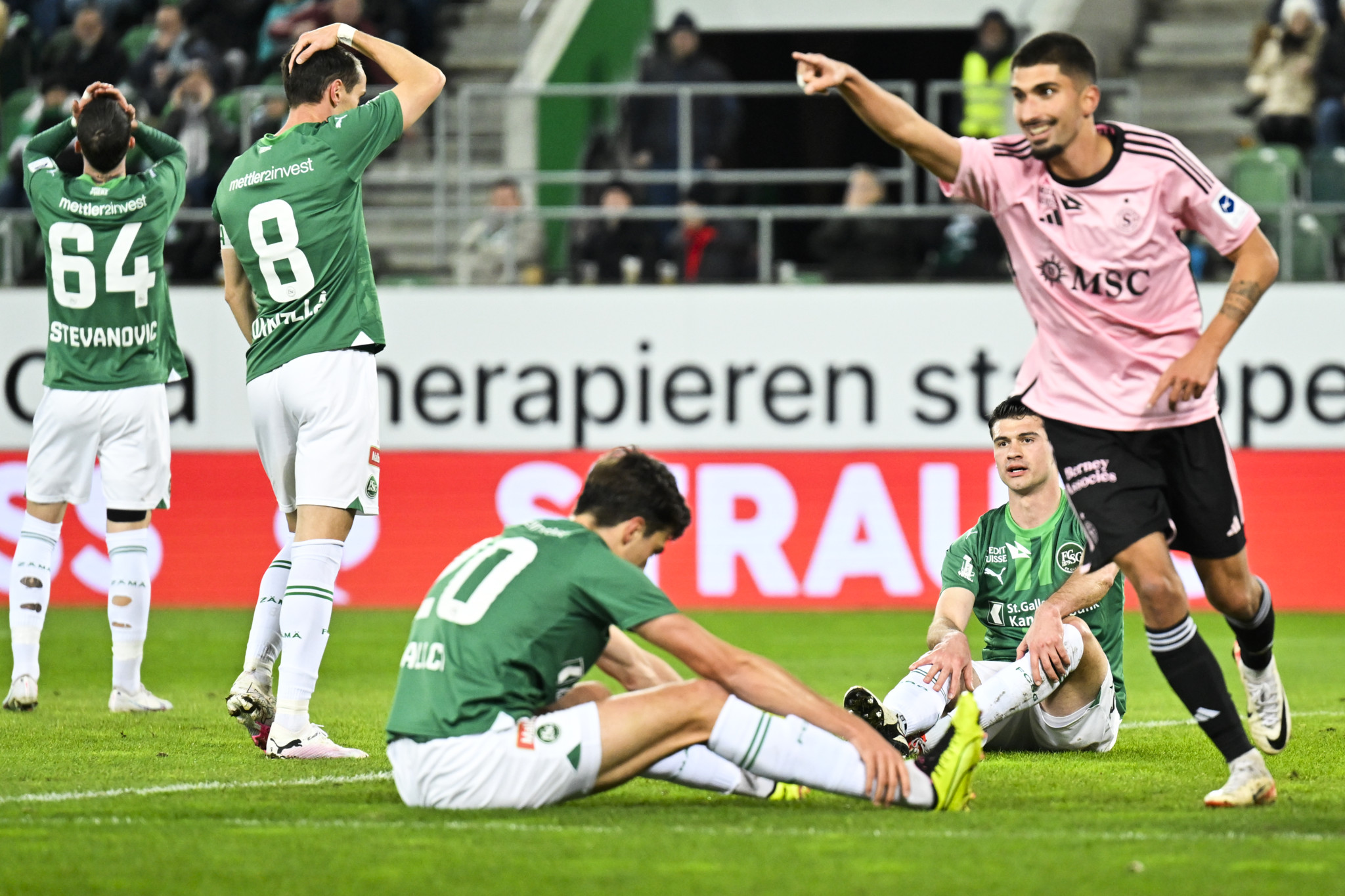 CAPTION CORRECTION: CORRECTS NAME - St. Gallens Jozo Stanic, zweiter von rechts, sitzt am Boden nach seinem Eigentor zum 0-1, Servettes Alexis Antunes, rechts, jubelt, im Fussball Super League Spiel zwischen dem FC St. Gallen und dem Geneve Servette FC, am Mittwoch, 31. Januar 2024, im Kybunpark in St. Gallen. (KEYSTONE/Gian Ehrenzeller)