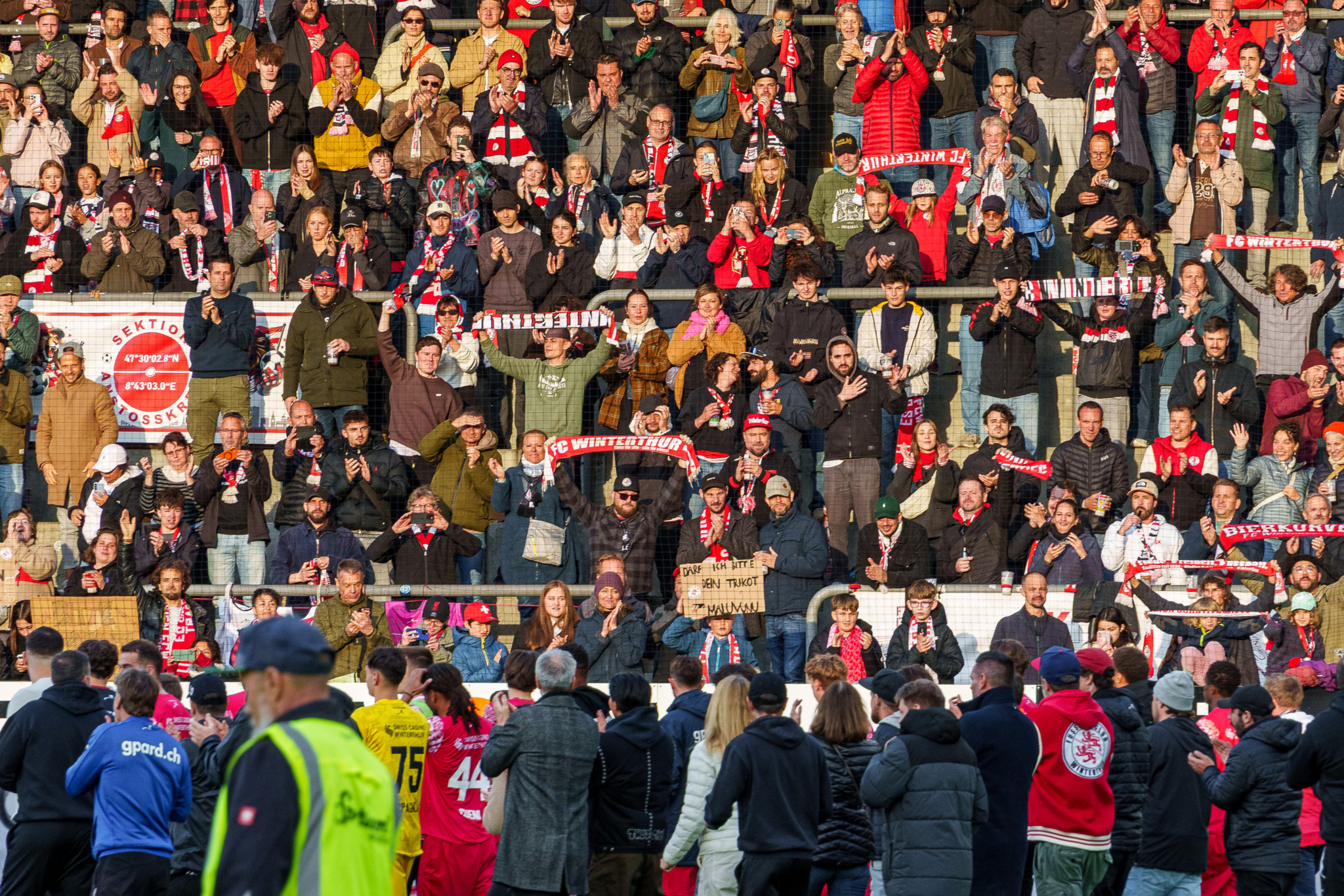 FC Winterthur Fans im Stadion Schützenwiese halten rot-weisse Schals und feiern beim letzten Super-League-Spiel gegen den FC Luzern.