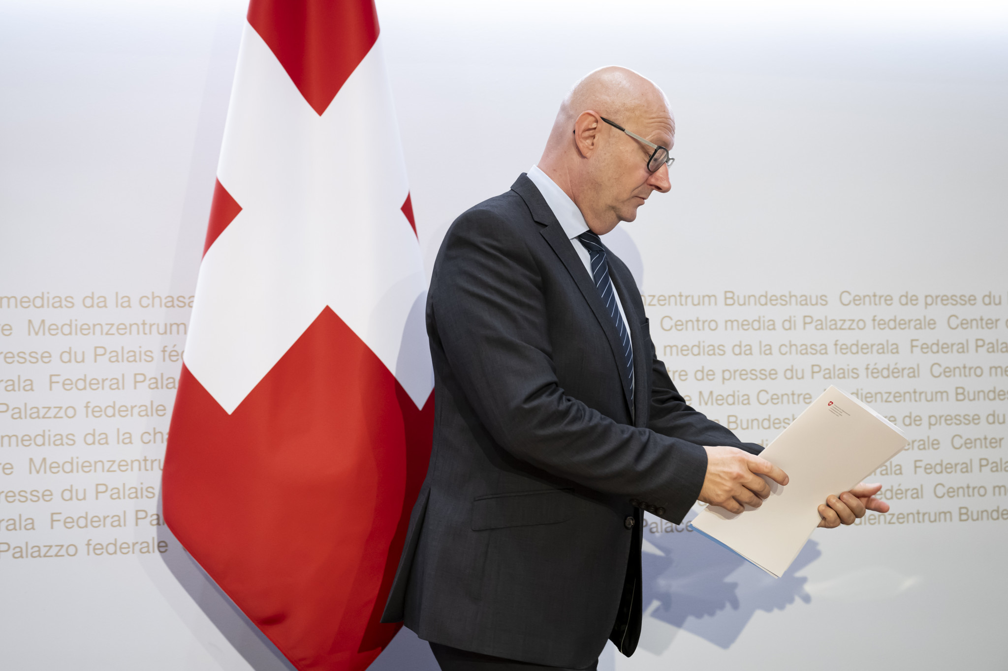 Viktor Rossi, Bundeskanzler, quitte une conférence de presse au Medienzentrum Bundeshaus à Berne le 13 septembre 2024, avec le drapeau suisse en arrière-plan.
