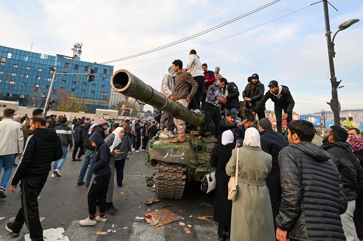Des personnes célèbrent sur un char à la place des Omeyyades à Damas le 8 décembre 2024, après la prise de la ville par les rebelles menés par les islamistes.
