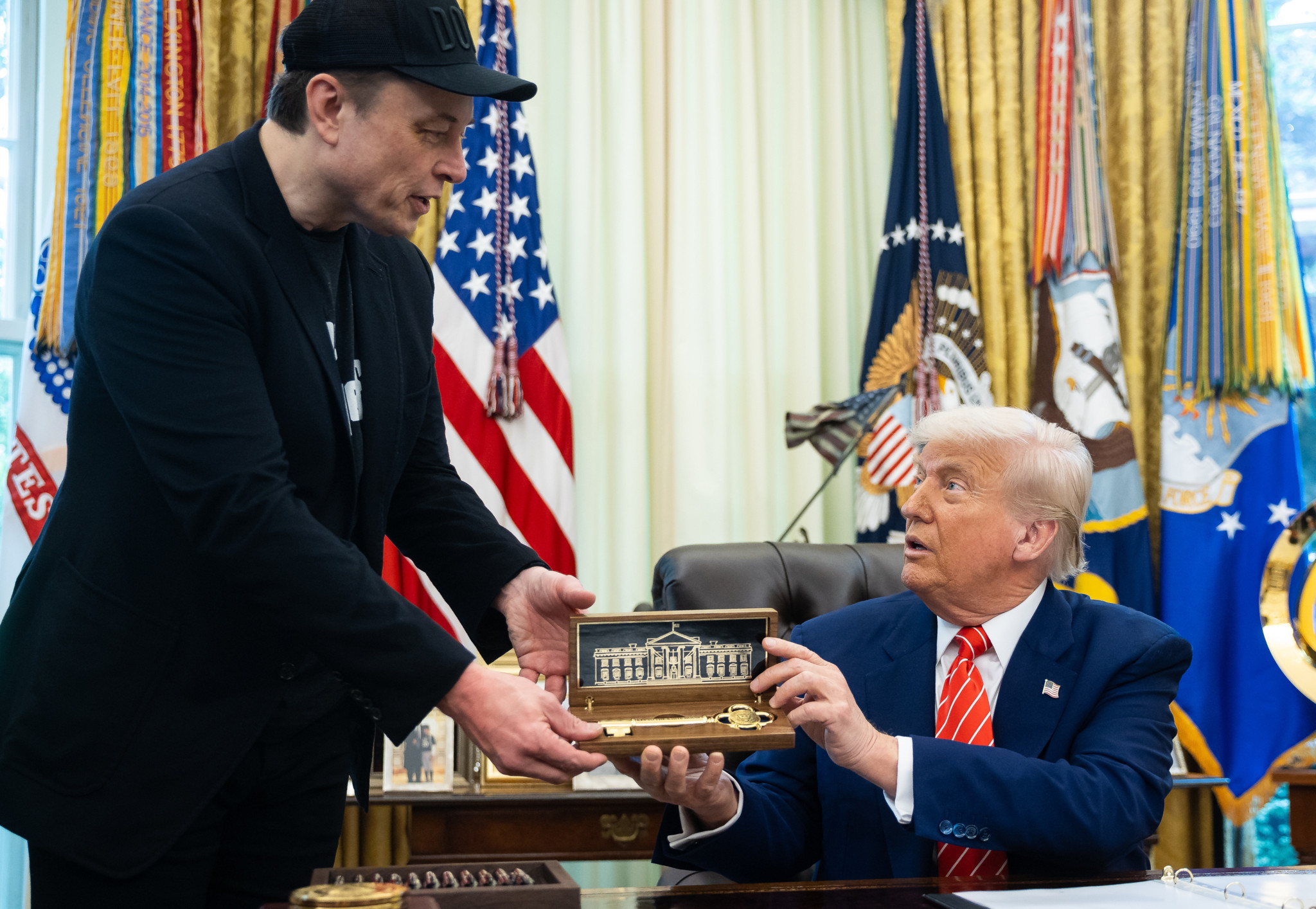 Elon Musk erhält ein Geschenk von US-Präsident Donald Trump während einer Pressekonferenz im Oval Office, 30. Mai 2025.