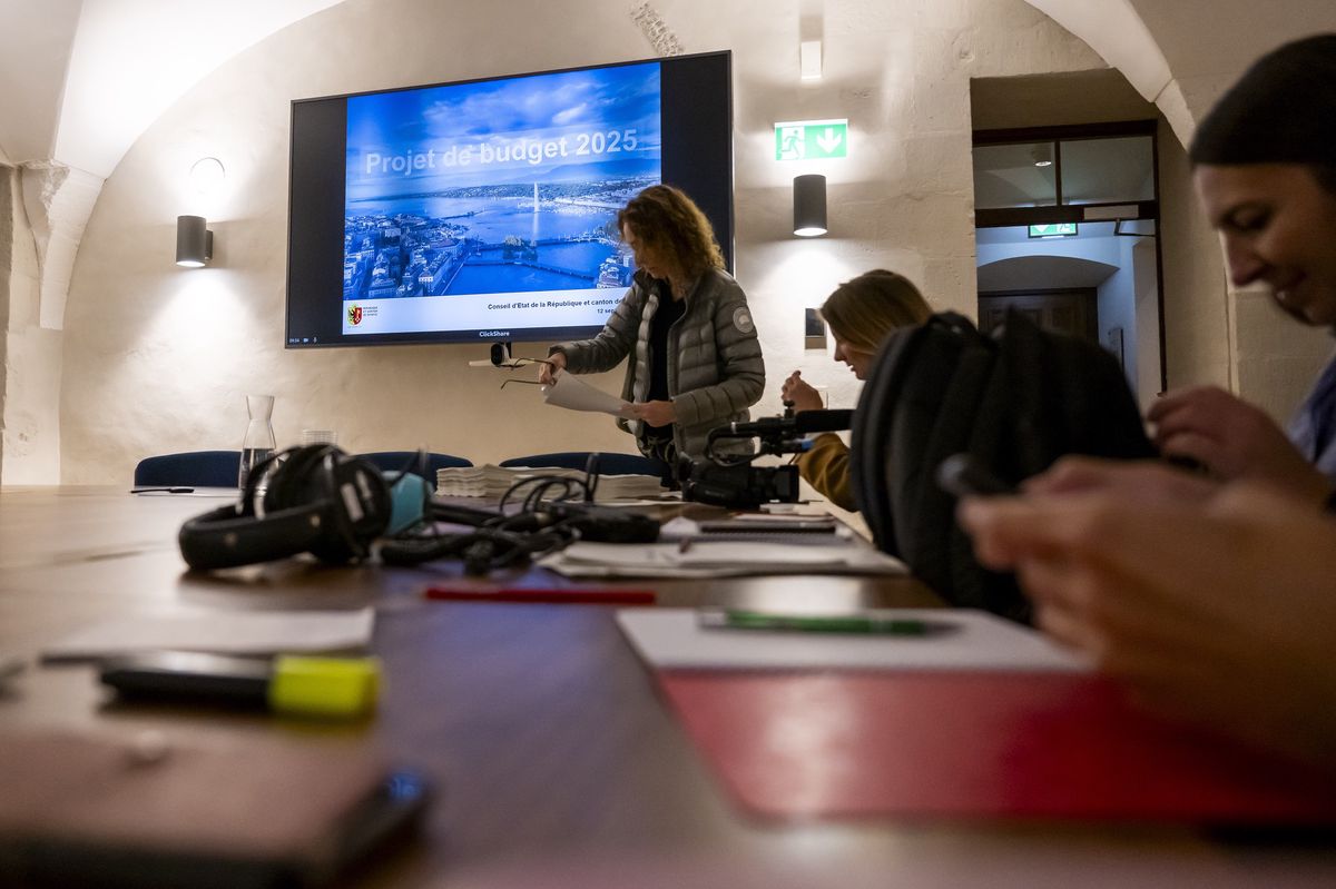 Des personnes assistent à une conférence de presse du Conseil d'Etat genevois, avec un écran affichant le projet de budget 2025, le 12 septembre 2024 à Genève.