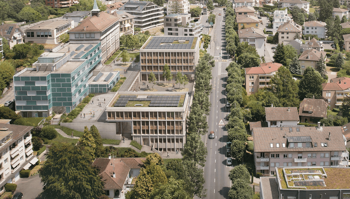 Vue aérienne d'un quartier urbain avec plusieurs bâtiments dotés de toits solaires et une route au centre bordée d'arbres.
