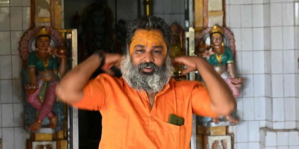 Hindu monk Mahant Haridas Udaseen (R), the sole registered voter at a polling station situated inside Gir Forest -- the last remaining natural habitat of the endangered Asiatic lion --, leaves to cast his ballot after offering prayers at a temple during the third phase of voting of India’s general elections at Baner on May 7, 2024. Deep inside a protected Indian forest, a Hindu monk cast his ballot on May 7, ensuring a 100 percent turnout at the polling station where he is the sole registered voter. India is in the midst of the largest exercise of the democratic franchise in human history and the country pledges to reach every voter, no matter where they live. (Photo by Indranil MUKHERJEE / AFP)