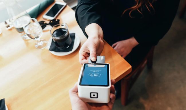 Frau bezahlt mit Karte in Restaurant 