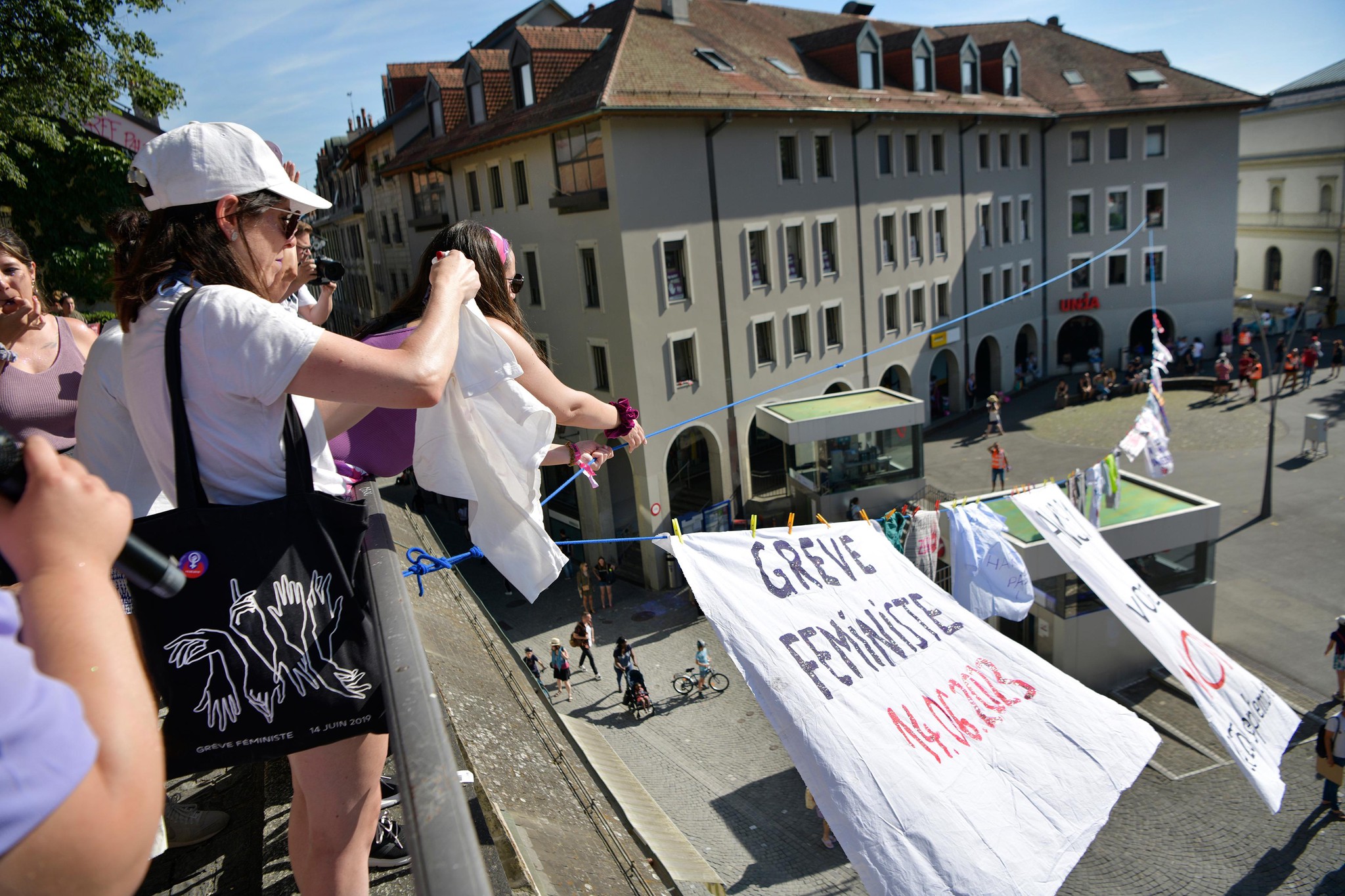 Parmi les happenings qui ont précédé le cortège sur la place de la Riponne, des militantes ont suspendu les habits de travail de plusieurs secteurs où les femmes ont de quoi revendiquer.