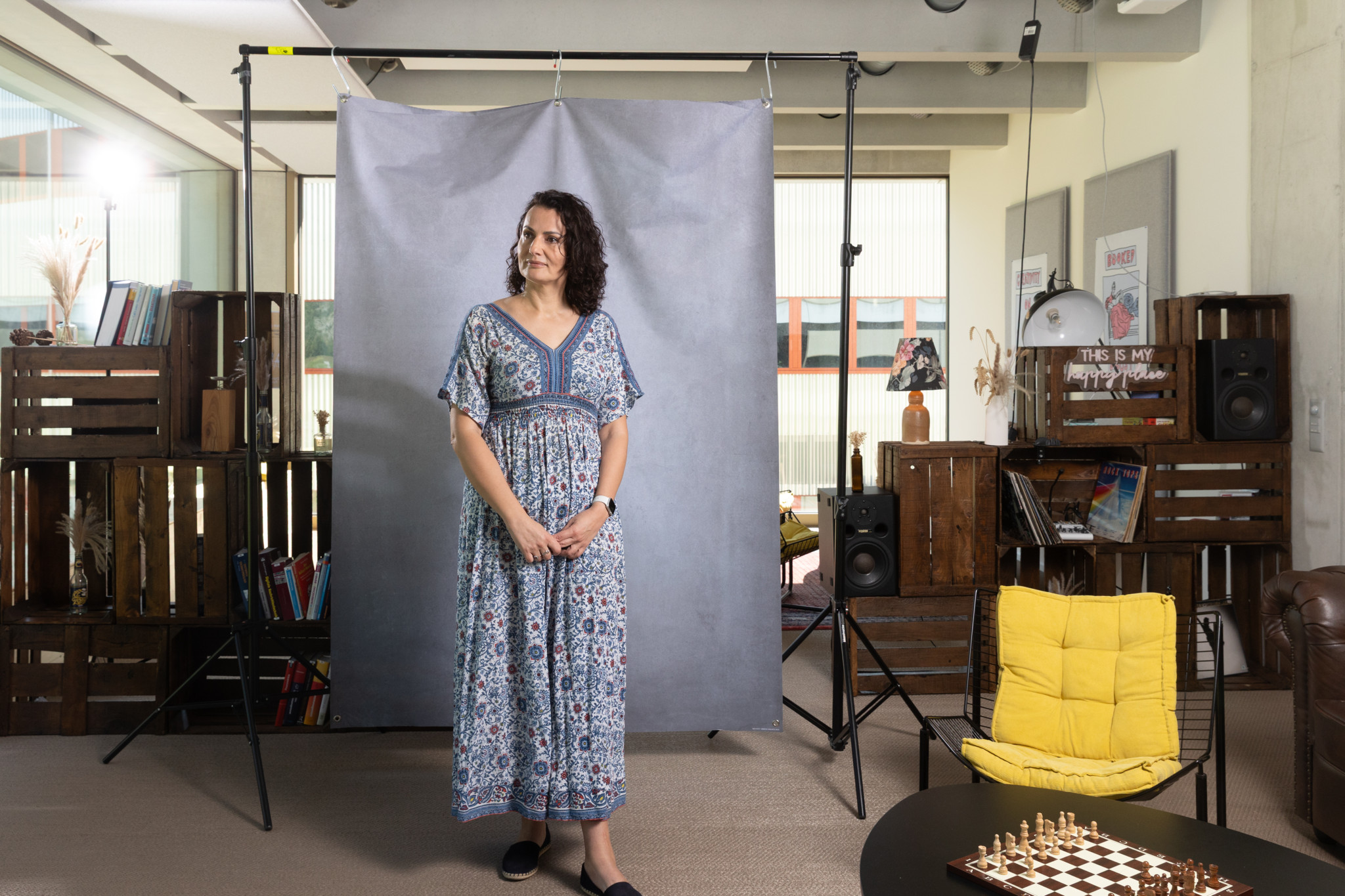 Amina Ovcina Cajacob während eines Fotoshootings in einem modernen Raum mit Bücherregalen und einem Schachbrett. Sie überlebte den Bosnienkrieg und ist jetzt Professorin an der FH Graubünden.