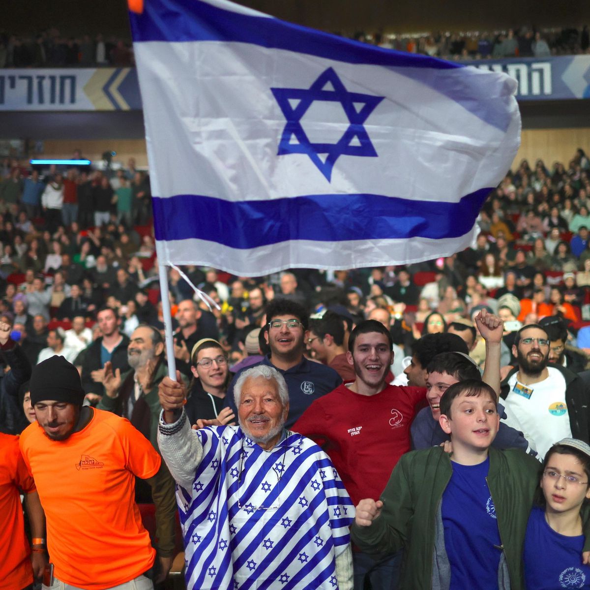 Des participants à une conférence d'extrême droite brandissent un drapeau israélien au Centre international de conférences à Jérusalem, le 28 janvier 2024.