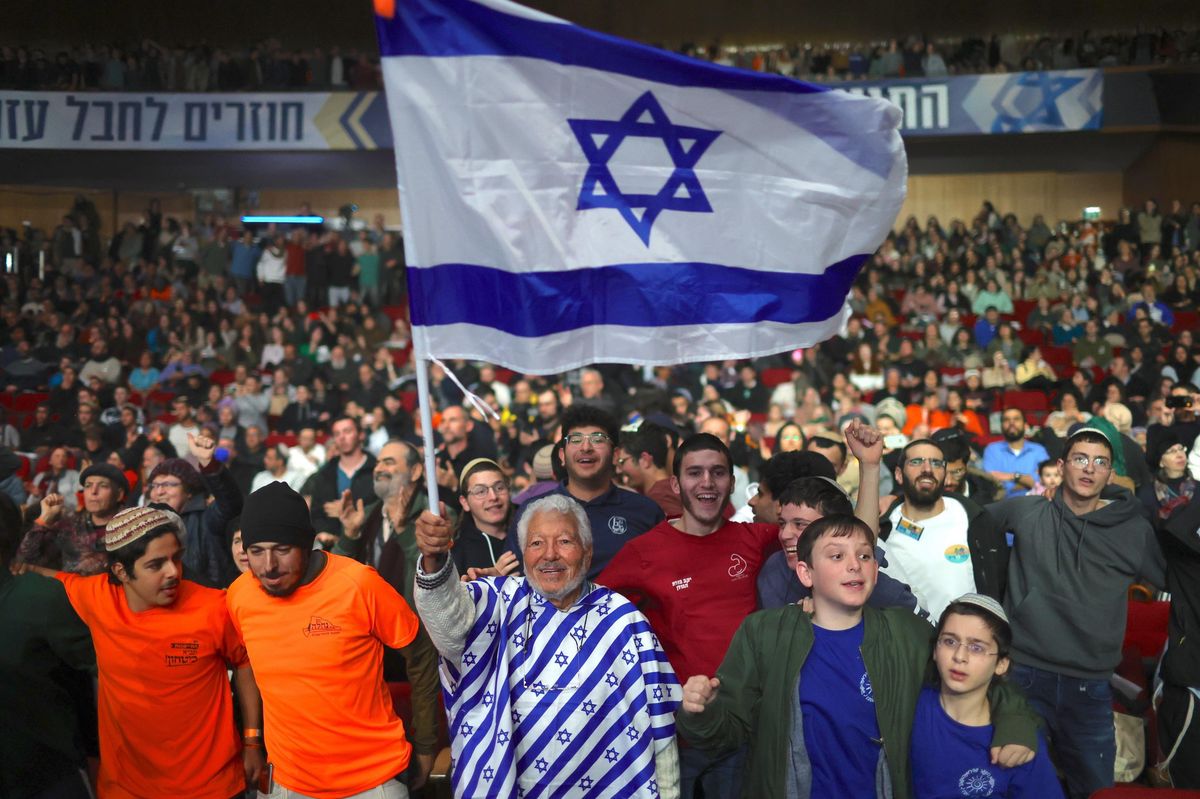 Des participants à une conférence d'extrême droite brandissent un drapeau israélien au Centre international de conférences à Jérusalem, le 28 janvier 2024.