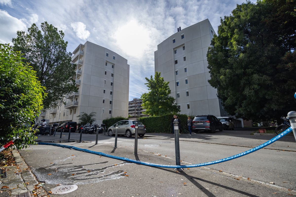 Deux immeubles résidentiels à Carouge, avec une zone de sécurité délimitée par un ruban bleu après une fuite de produit chimique. Une installation d'accès à l'eau potable par une bouche incendie est visible au premier plan. Photo Pierre Albouy/Tribune de Genève.