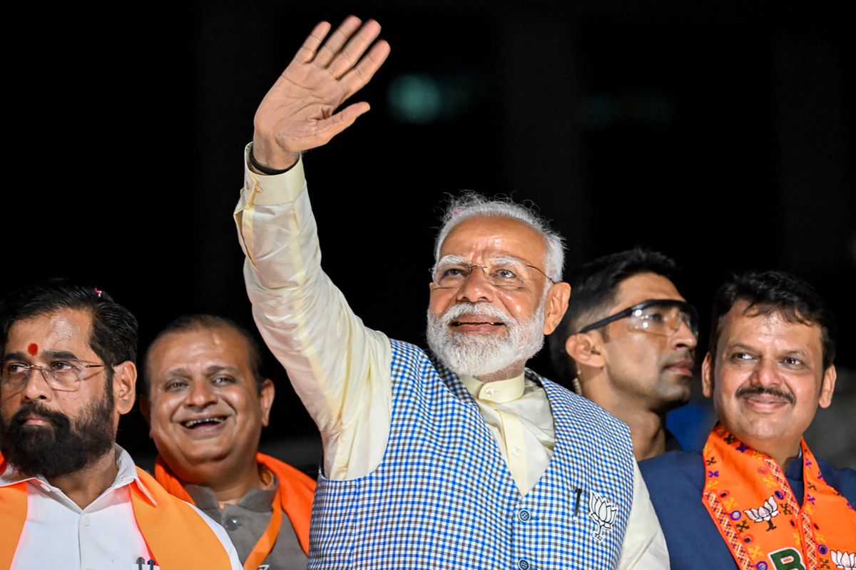 India's Prime Minister and leader of the ruling Bharatiya Janata Party (BJP) Narendra Modi (C) with chief minister of Maharashtra state Eknath Shinde (L) and their deputy chief Minister Devendra Fadnavis (R) waves to the crowd during his roadshow in Mumbai on May 15, 2024, ahead of the fifth phase of voting of India's general election. (Photo by Punit PARANJPE / AFP)