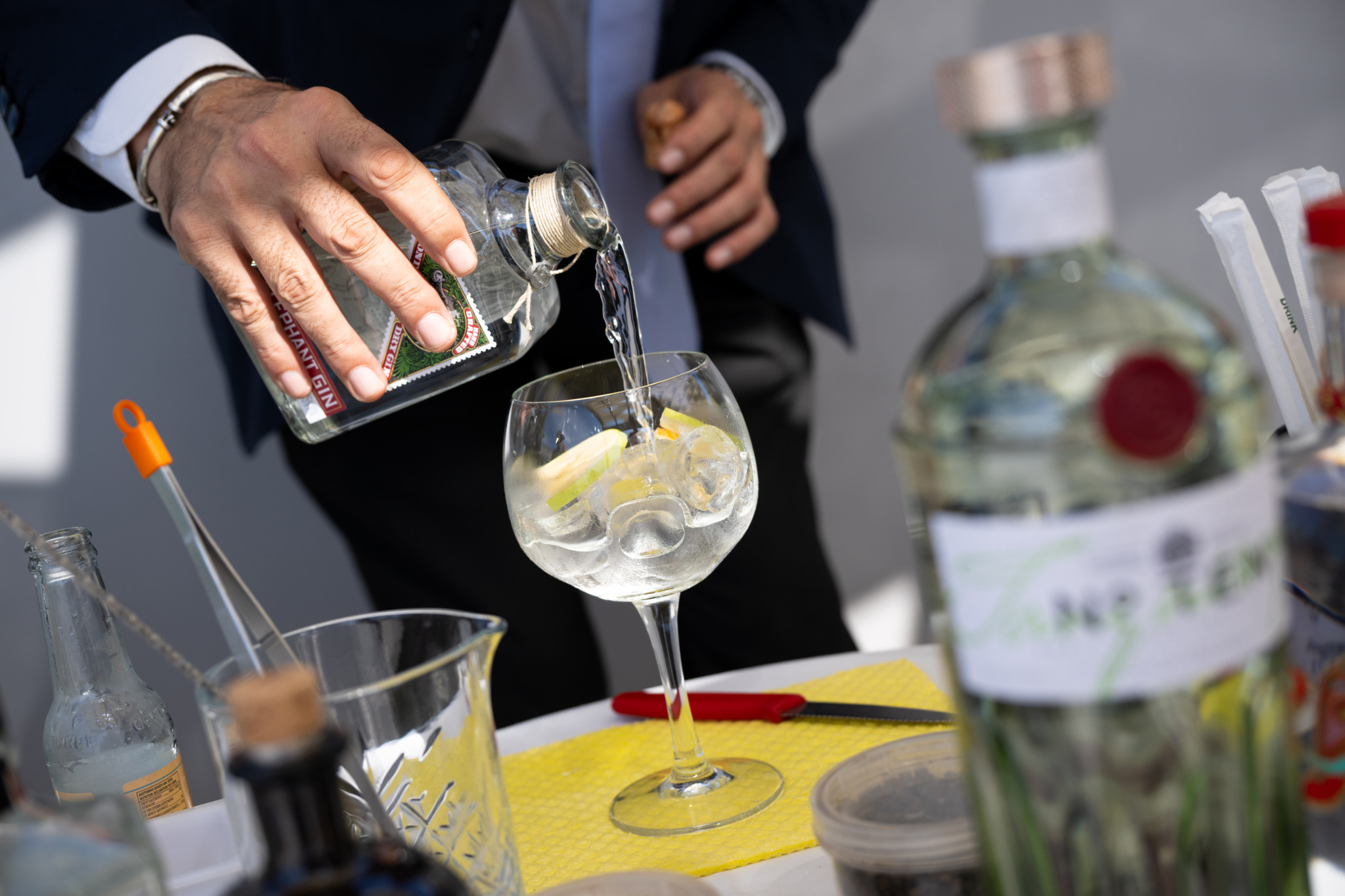 Barkeeper giesst Gin in ein Weinglas mit Eis und Zitrone bei einer Cocktail-Demonstration im Constantinou Bros Asimina Suites Hotel in Paphos, Zypern.