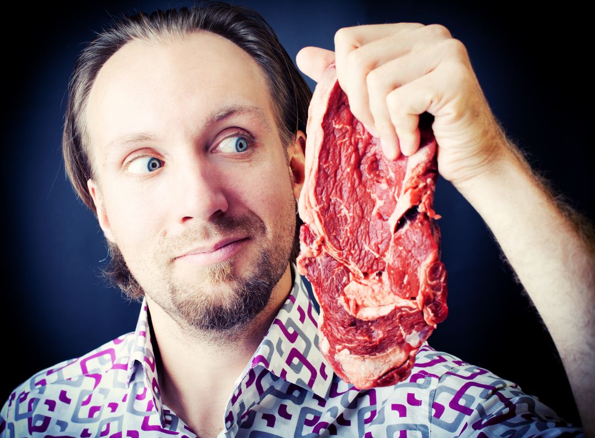 "Man holding ribeye steak, toned image"