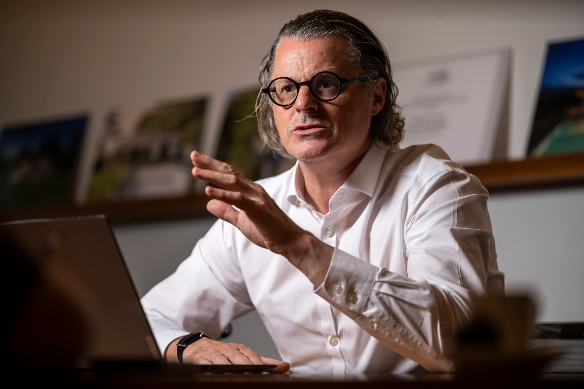 Claude Ginesta, CEO von Ginesta Immobilien, sitzt am Schreibtisch vor einem Laptop und gestikuliert während eines Gesprächs.