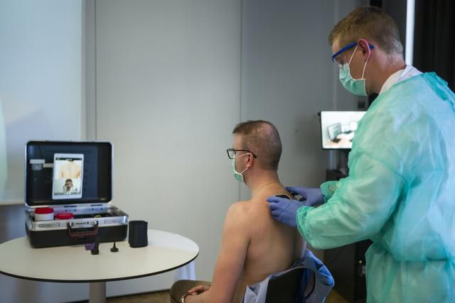 Un infirmier auxiliaire examine les poumons d'un patient, les données de l'examen sont envoyées grâce à la télémédecine.