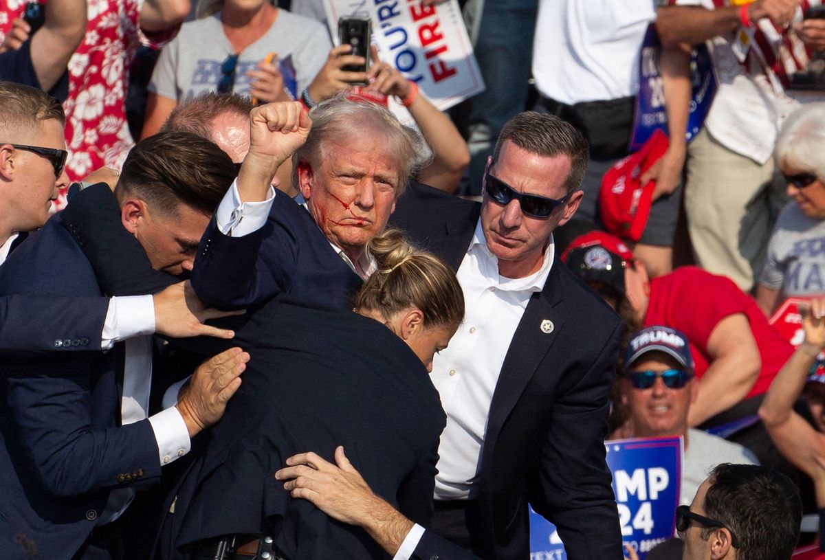 (FILES) Republican candidate Donald Trump is seen with blood on his face surrounded by secret service agents as he is taken off the stage at a campaign event at Butler Farm Show Inc. in Butler, Pennsylvania, July 13, 2024. A Florida judge appointed by Donald Trump has dismissed the criminal case against the former president on charges of mishandling top secret documents, on July 15, 2024 saying the way that Special Counsel Jack Smith was appointed was improper. (Photo by Rebecca DROKE / AFP)