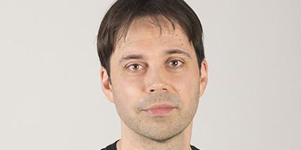 Homme en t-shirt noir sur un fond blanc.