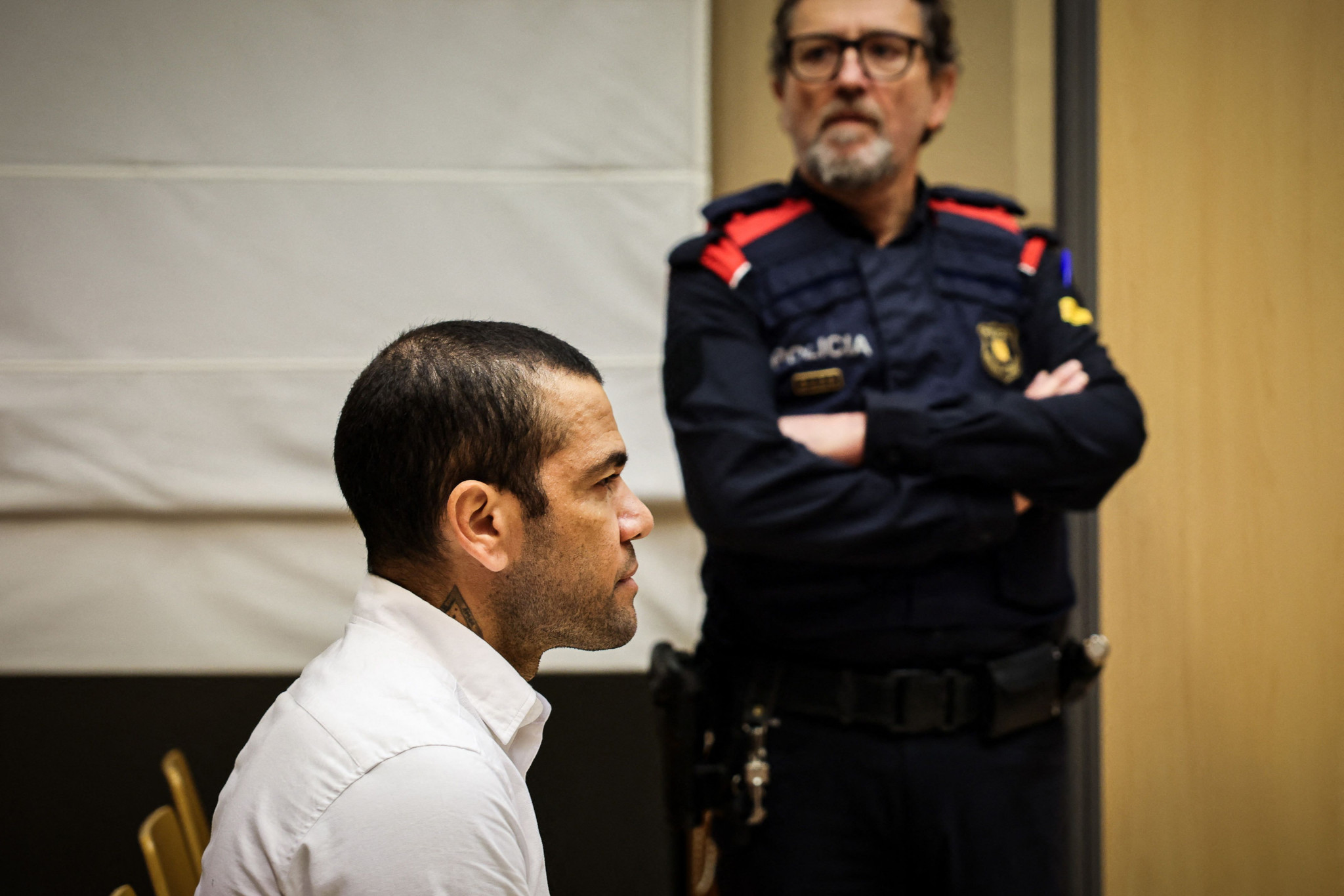 Brazilian footballer Dani Alves looks on at the start of his trial at the High Court of Justice of Catalonia in Barcelona, on February 5, 2024. Brazilian footballer Dani Alves, a former star at Barca and PSG, goes on trial in Barcelona accused of raping a woman in a local nightclub. Prosecutors are asking for a nine-year prison sentence, followed by 10 years of conditional liberty. They are also asking he pay 150,000 euros ($162,000) in compensation to the woman. (Photo by Jordi BORRAS / POOL / AFP)